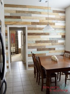 a dining room table and chairs in front of a wooden wall with vertical planks