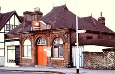 an old brick building on the corner of a street with a red door and window