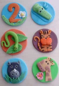 there are six decorated cookies in the shape of animals and numbers on top of each cookie