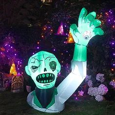 an inflatable statue of a zombie holding his hand up to the sky, surrounded by christmas lights