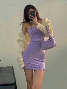 a woman taking a selfie while wearing a purple dress