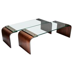 a glass and wood coffee table with metal accents on the top, in front of a white background