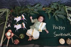 a baby laying on top of a green blanket next to other foods and vegetables with the words happy sankikati written on it