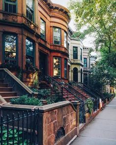 a row of browns houses on a city street with stairs leading up to the second story