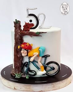 a birthday cake with a boy riding a bike on the front and number 50 on the back