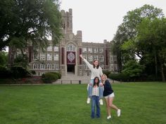 three people standing in front of a large building