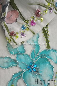 the fabric has been sewn together with beaded flowers and beads on it's sides