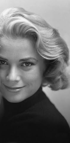 a black and white photo of a woman with blonde hair wearing a turtle neck sweater