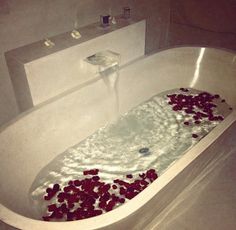 a bathtub filled with water and rose petals