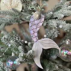 an ornament hanging from a christmas tree with ornaments on it's branches