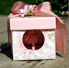 a small pink box with a bow on top