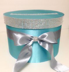 a blue and silver box with a bow on the top is sitting on a table