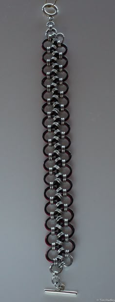 This is a chainmail bracelet made of Bright Aluminum (silver) and Anodized Aluminum (colors). It is a Japanese Lace chain ithat is back on one side and red not he other. I can lengthen or shorten it (additional $5/inch to lengthen) or change the clasp (price depends on clasp selected). Why aluminum? It's lightweight yet strong, making it comfortable to wear yet durable. It does not tarnish, but there are rare instances of a slight grey rub-off that can occur. This easily washes off. If the jewelry becomes dirty or dingy, it can be washed with soap and water or a vinegar and baking soda soak. I can make similar items in different weights or colors, as well as different materials such as stainless steel, sterling silver, copper, argentium, and more. If you don't see exactly what you want, co Red Metal Chain Bracelet, Chainmaille Jewelry Patterns, Chainmail Patterns, Chainmail Bracelet, Hardware Jewelry, Chainmail Jewelry, Lace Bracelet, Chain Maille Jewelry, Bracelet Men