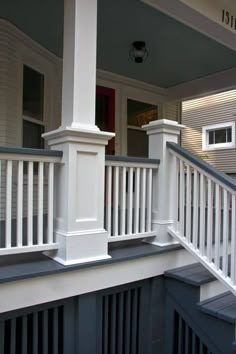 a porch with white railings and blue siding