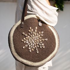 Handcrafted with meticulous care, this exceptional bag is a true gem for women who appreciate unique accessories. It's meticulously hand-knitted from organic raffia material, adorned with delicate natural seashell embellishments, making it an ideal companion for everyday use, beach getaways, and summer adventures. **Organic Raffia Material Crafted from organic raffia, this bag exudes natural beauty and eco-friendliness. The hand-knitted design showcases skilled craftsmanship and attention to det Luxury Beach Bag For Vacation, Elegant Beach Bag With Leather Handles, Luxury Crochet Travel Bag With Detachable Handle, Gift Bag With Removable Pouch And Round Handle, Luxury Beach Bag For Daily Use, Elegant Handwoven Shoulder Bag, Luxury Large Capacity Bags For Vacation, Luxury Large Capacity Vacation Bag, Luxury Crochet Satchel Bag For Travel