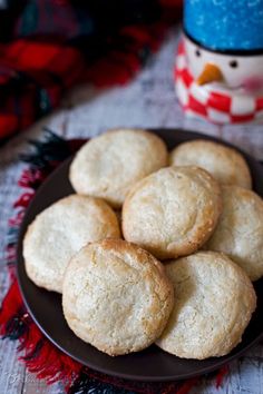 some cookies are on a black plate with a red and white table cloth next to a snowman