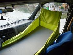 the interior of a car with a sleeping cot in the back