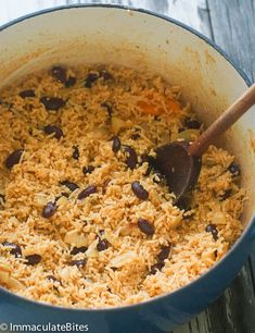 a pot filled with rice and beans on top of a wooden table