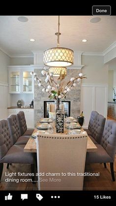 the dining room table is set up for four with gray chairs and a chandelier