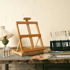 an easel and other art supplies sit on a table