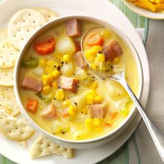 a white bowl filled with soup next to crackers