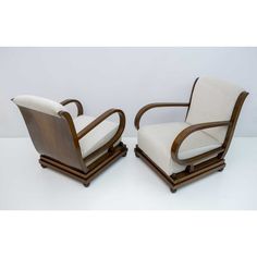 a pair of art deco chairs with white upholstered cushions