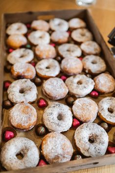 a box filled with lots of donuts on top of a wooden table