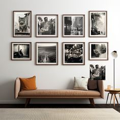 a living room with pictures on the wall and a couch in front of an ottoman