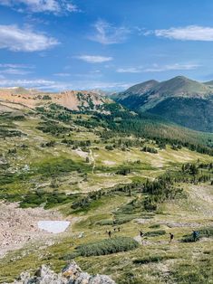 people hiking in the mountains on a sunny day