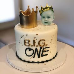 there is a cake that has two small crowns on it and the words'big one'are placed next to each other