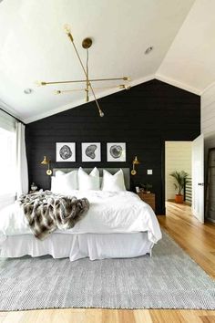 a bedroom with black walls, white bedding and wooden floors is pictured in this image