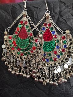 * The astonishing Afghani pair of earrings are an authentic traditional ornament of mountain regions. The pair is beautifully embellished with multi color stones and silver dangling beads. * The tear drop shape like earrings have engraved circular and tear drop designs in which glass stone is embedded. The silver beads at the bottom are nothing but making this piece an epitome of tradition. * You can pair them with any attire or style, traditional or trendy, it is on you. But they would get alon Bohemian Green Chandelier Earrings For Festive Occasions, Traditional Multicolor Drop Earrings, Festive Traditional Plug Earrings, Festive Multicolor Earrings, Traditional Chandbali Plug Earrings For Celebration, Traditional Heavy Earrings For Rituals, Traditional Green Chandelier Earrings For Celebration, Green Pendant Earrings For Festive Occasions, Multicolor Latkans Earrings For Rituals