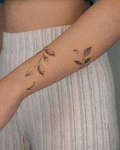 a woman's arm with leaves on it