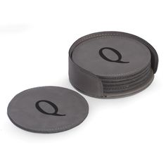 a stack of grey coasters with the letter q on each one and an o at the bottom