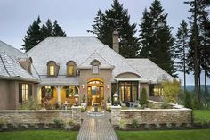 a large house with lots of windows and stone walkway leading up to the front door