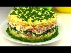 there is a layered cake on the plate with green onions and other ingredients around it