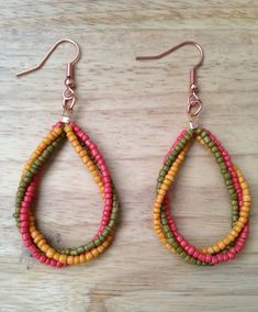 two pairs of beaded earrings on top of a wooden table