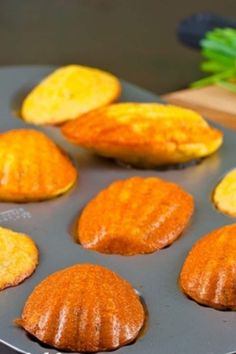 some baked treats are sitting in a muffin tin with the words parmesan, chive & garlic madeine's on it