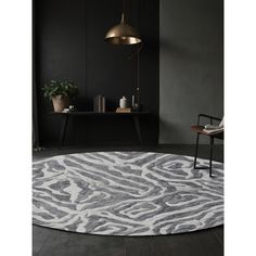 a round rug with an animal print pattern on the floor in front of a black wall