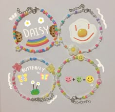 the four bracelets are decorated with smiley faces, eggs, and rainbow - colored beads