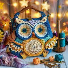 an owl purse sitting on top of a table next to yarn and crochet