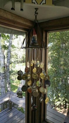 a wind chime hanging from the side of a wooden porch next to a window