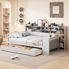 a white bed sitting on top of a wooden floor next to a book shelf filled with books