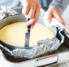 a person is using a knife to cut something in tin foil on top of a pan