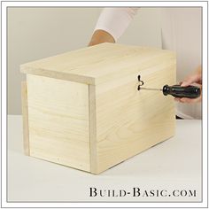 a person using a knife to cut a piece of wood with a box on the table