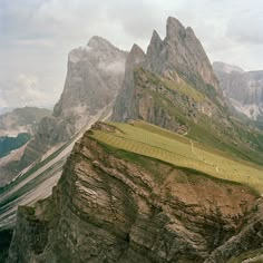 a grassy field on the side of a mountain