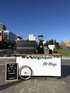 an ice cream cart on the sidewalk in front of some buildings