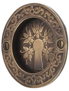 an ornate brass plate with a keyhole and flowers on it