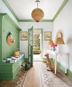 a hallway with green painted walls and white trim on the doors, windows, and rugs