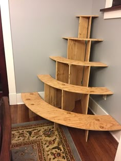 a wooden shelf sitting on top of a hard wood floor next to a rug and door